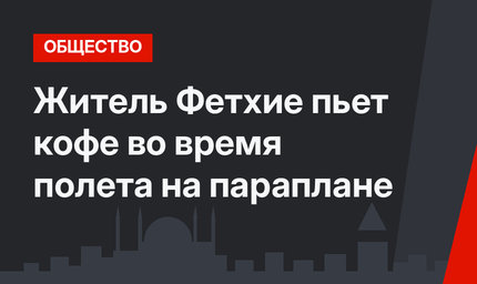Житель Фетхие пьет кофе во время полета на параплане